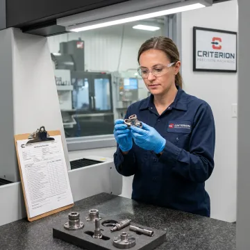 Engineer inspecting AS9100 machined aerospace parts