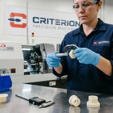 Technician inspecting CNC turned plastic part