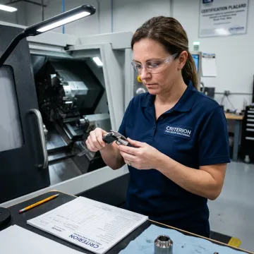 Machinist inspecting precision defense components