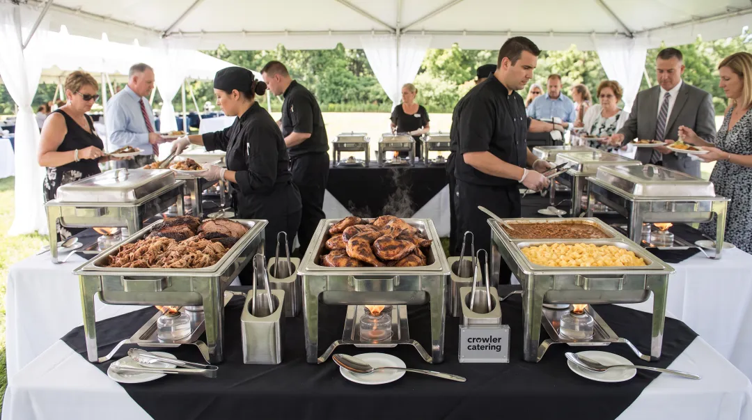 Professional BBQ buffet station with chafing dishes warming trays and organized food service setup