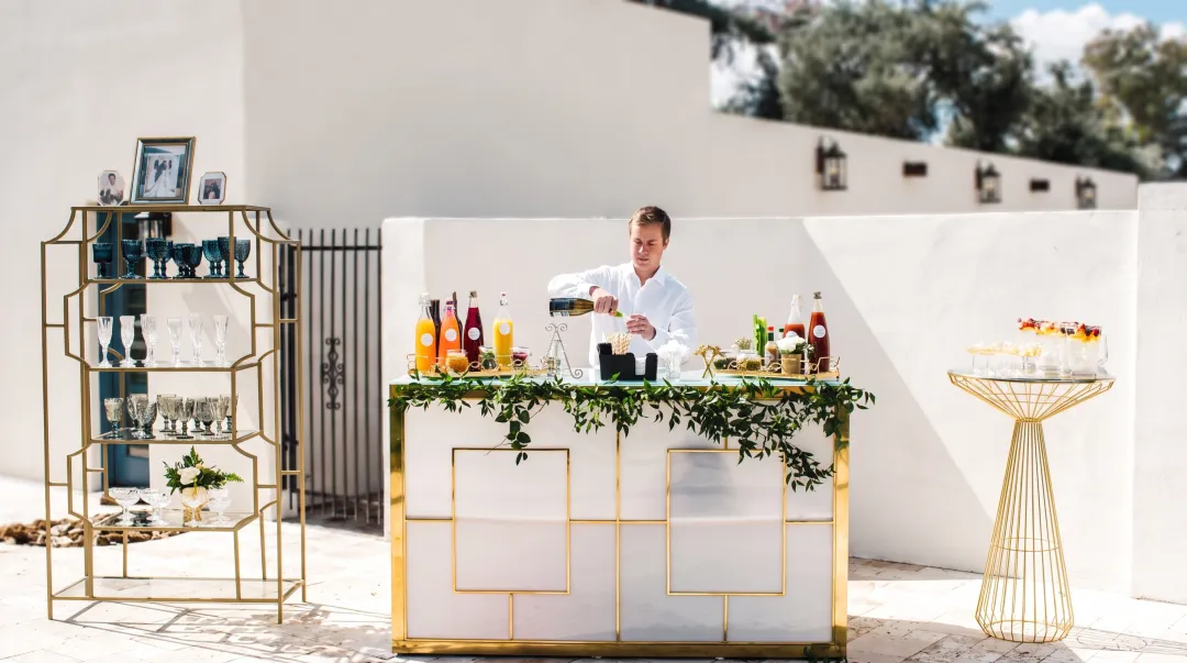 Professional bartender preparing craft cocktails at mobile bar setup for large event