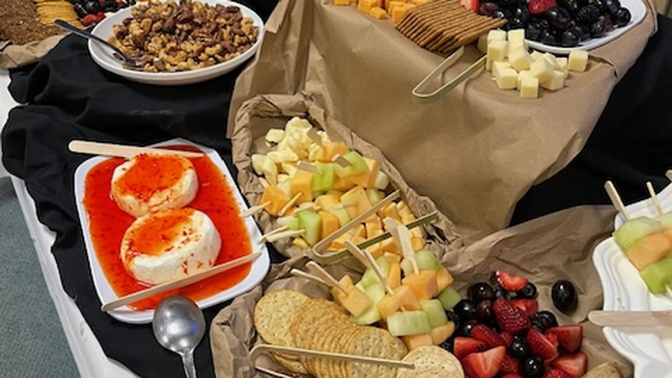 Elegant wedding charcuterie display on marble serving board with decorative arrangement