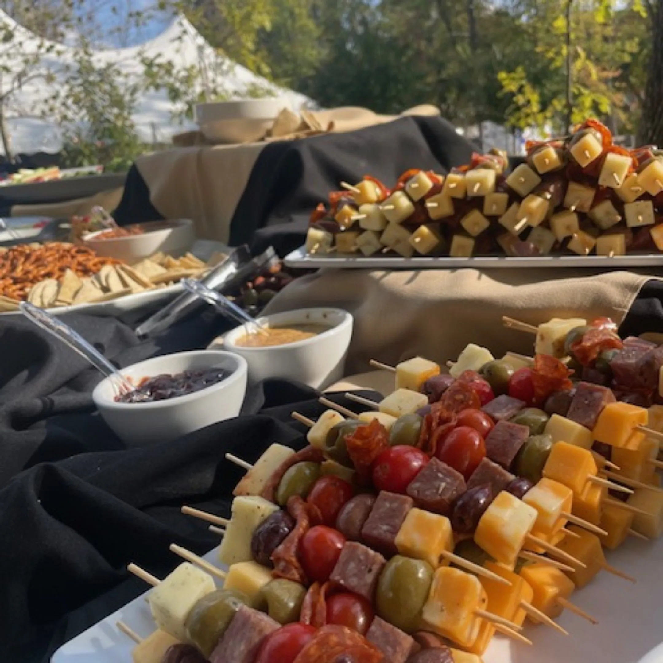 Bartender serving cocktails beside a catered spread