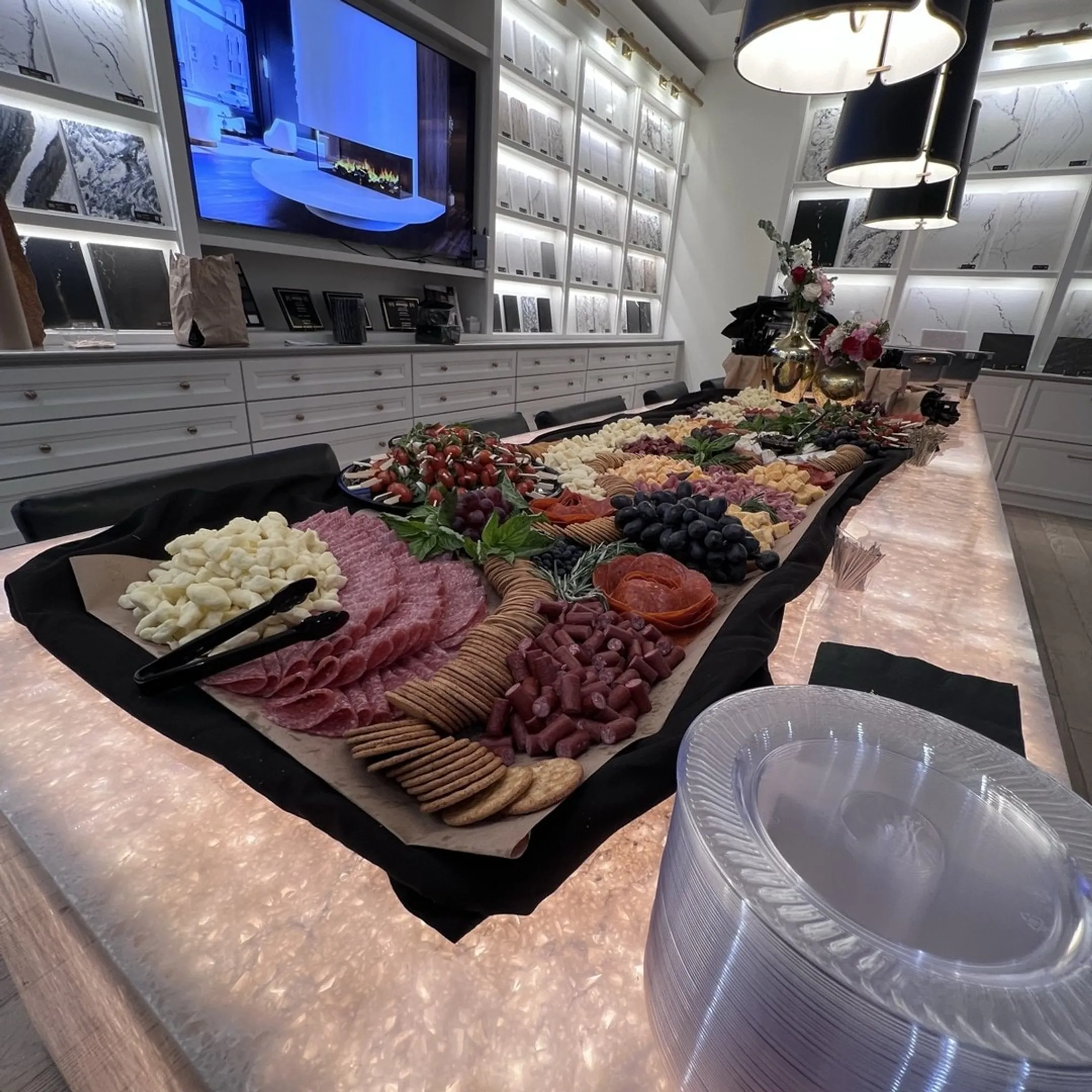 Bartender serving cocktails beside a catered grazing table
