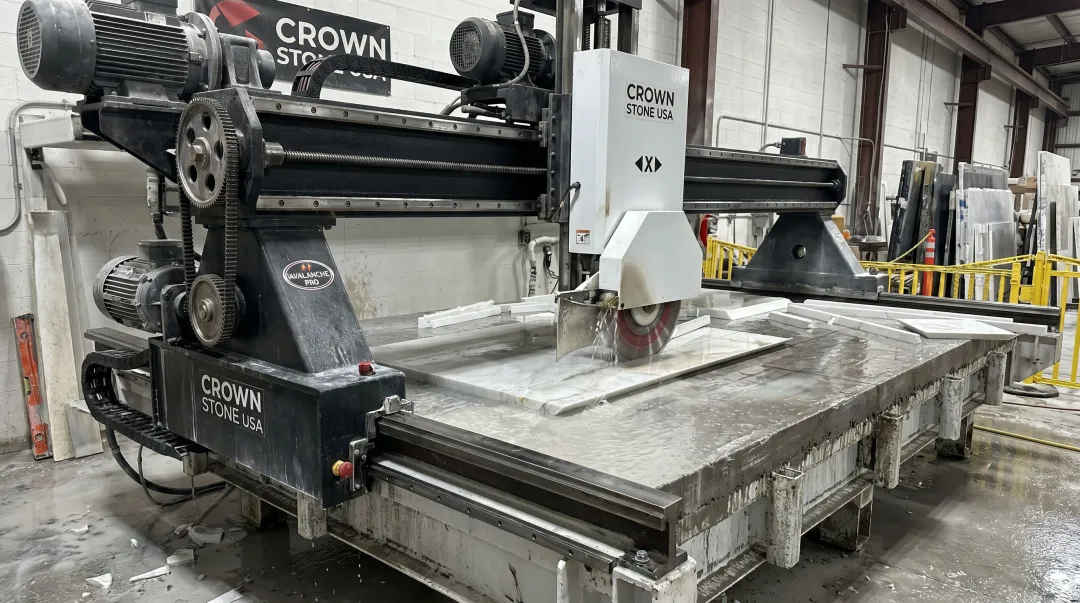 American-made bridge saw cutting granite slab in fabrication shop