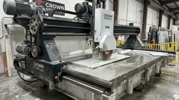 American-made bridge saw cutting granite slab in fabrication shop
