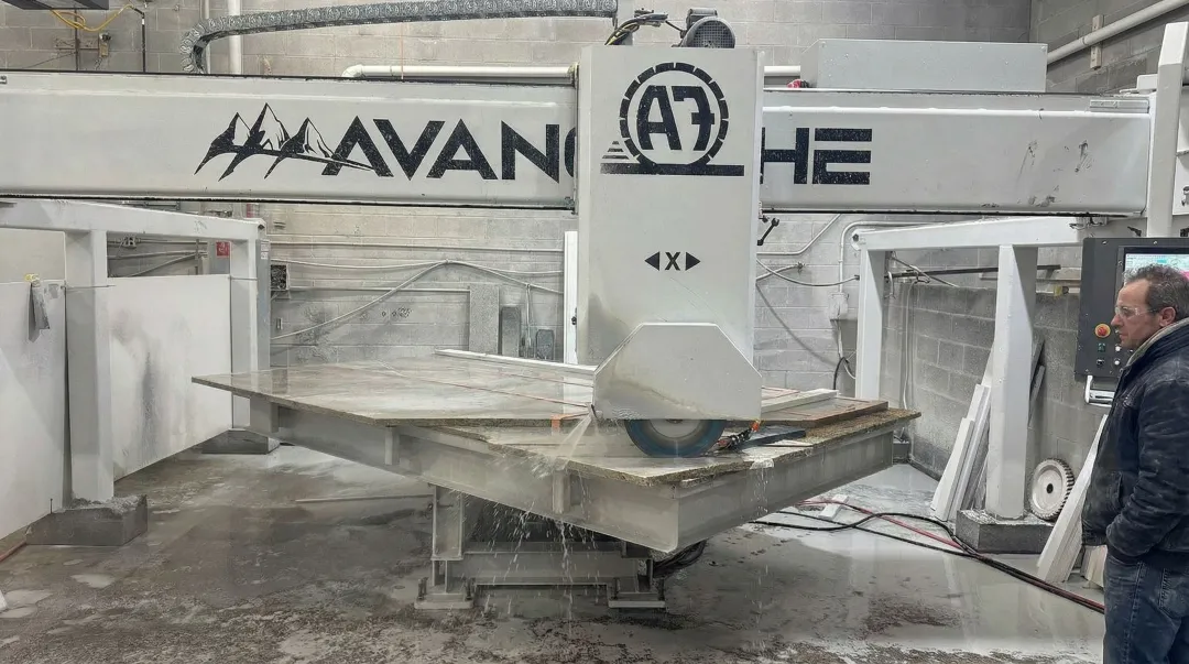 Bridge saw cutting granite slab with diamond blade on gantry system
