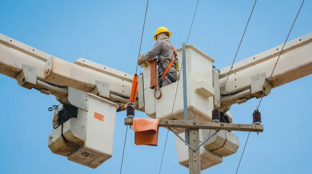 Insulated aerial bucket truck operator working near energized utility power lines