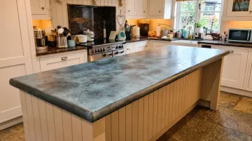 Zinc countertop island with blue-gray patina in farmhouse kitchen setting