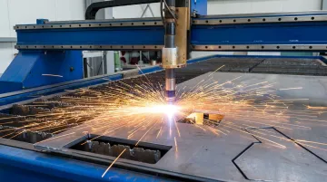 CNC plasma cutter cutting mild steel with orange sparks and oxygen assist gas