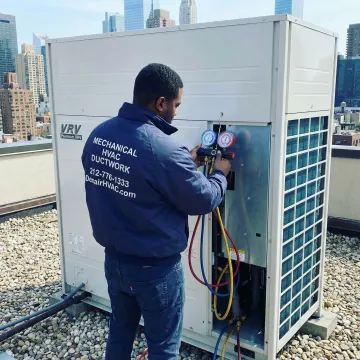 HVAC technician checking refrigerant levels on a VRV outdoor condensing unit on a Brooklyn rooftop