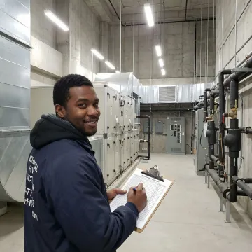 HVAC maintenance technician reviewing commercial system checklist inside Manhattan office building