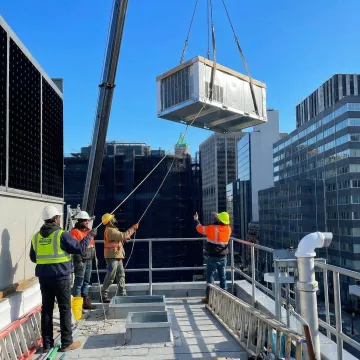 HVAC team installing a packaged rooftop unit on a commercial building in Queens NY