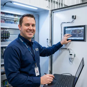 Certified HVAC technician programming a building automation system controller