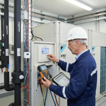HVAC technician commissioning a VRV air conditioning system in a commercial building