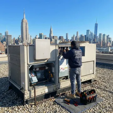 HVAC technician servicing a commercial rooftop unit in Manhattan, New York City