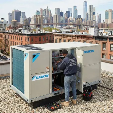 Certified HVAC technician repairing a Daikin rooftop unit on a Brooklyn commercial building
