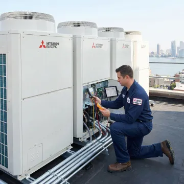 HVAC technician servicing a Mitsubishi City Multi VRF system on a rooftop