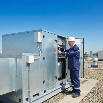 Certified HVAC technician servicing a commercial rooftop unit on a Long Island building