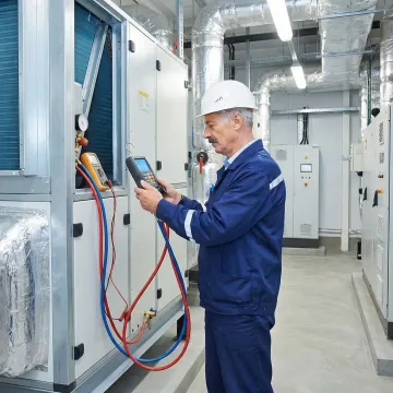 HVAC technician commissioning a new commercial AC system inside a Brooklyn office building