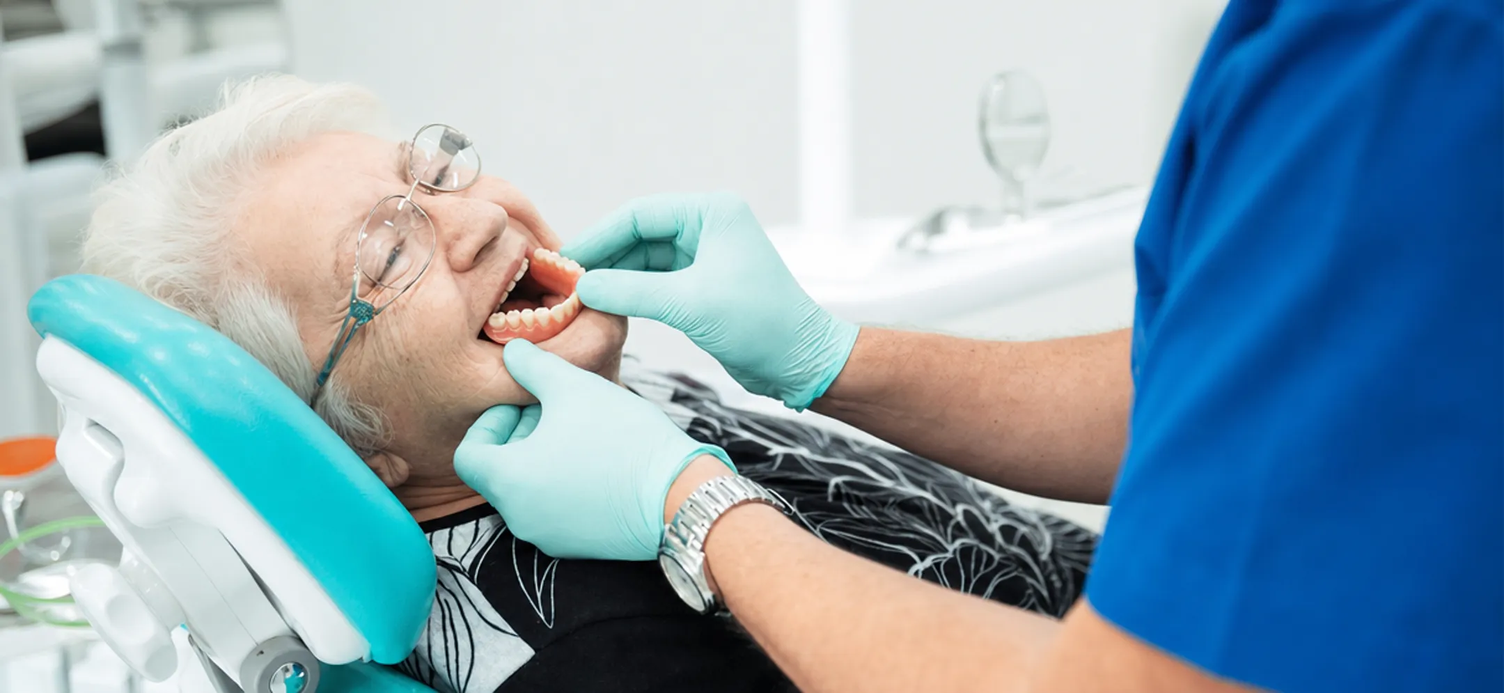 Dentist examining patient fitting for removable denture prosthetic
