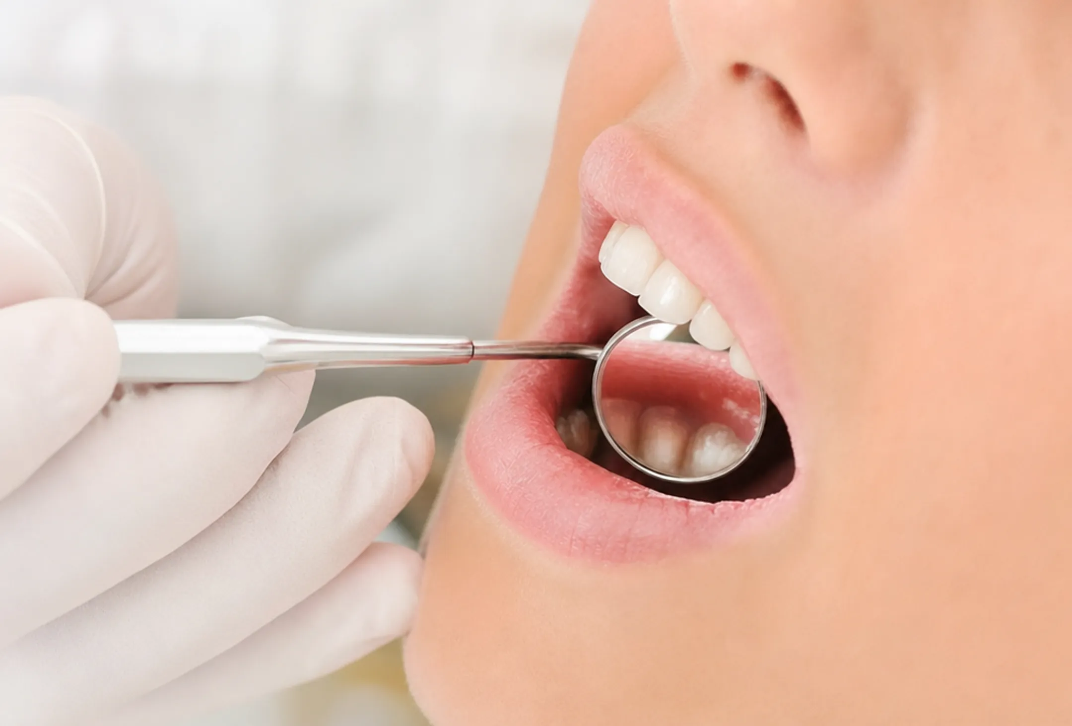 Dentist examining patient smile with natural looking porcelain crown restoration