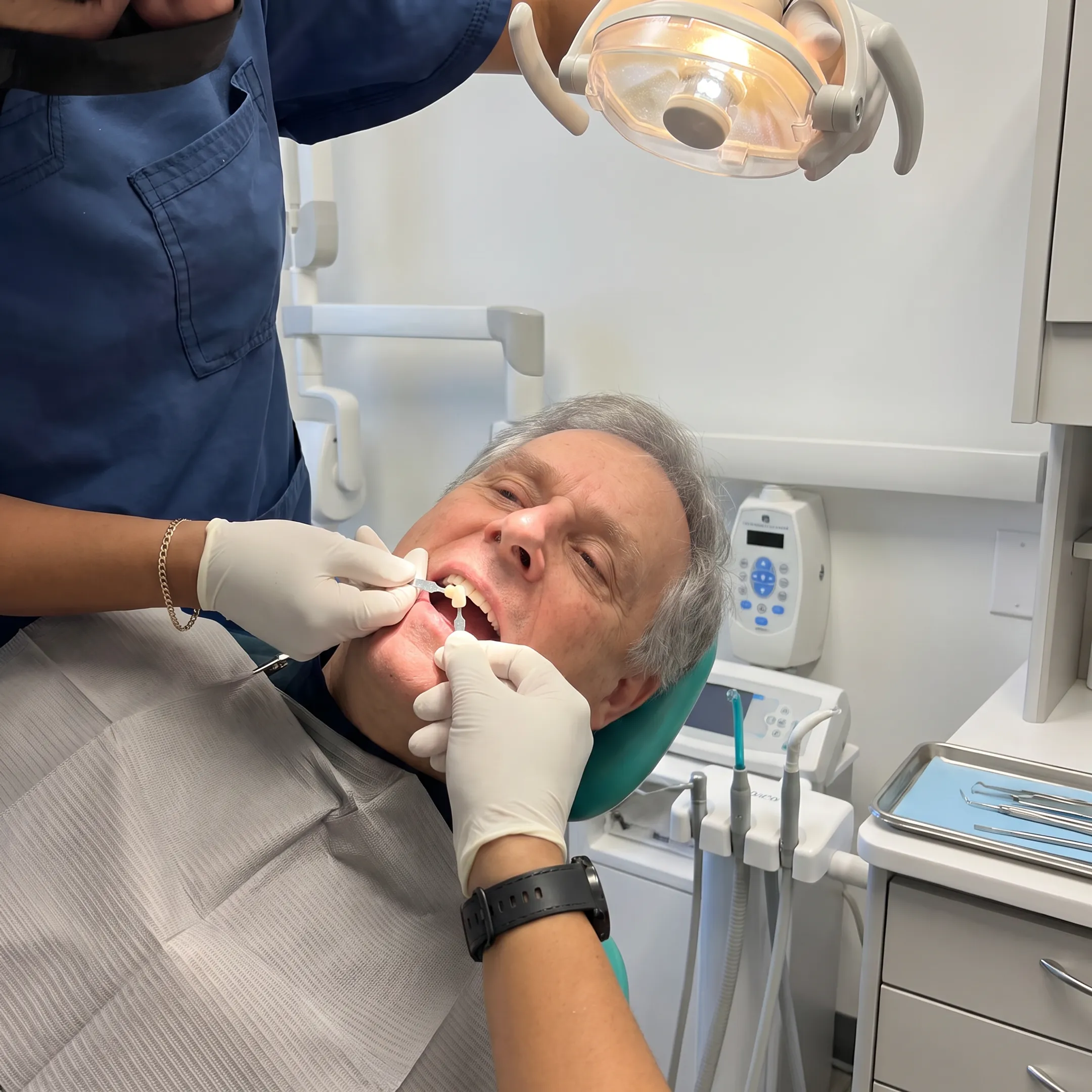 Dental professional comparing ceramic crown shades beside a patient