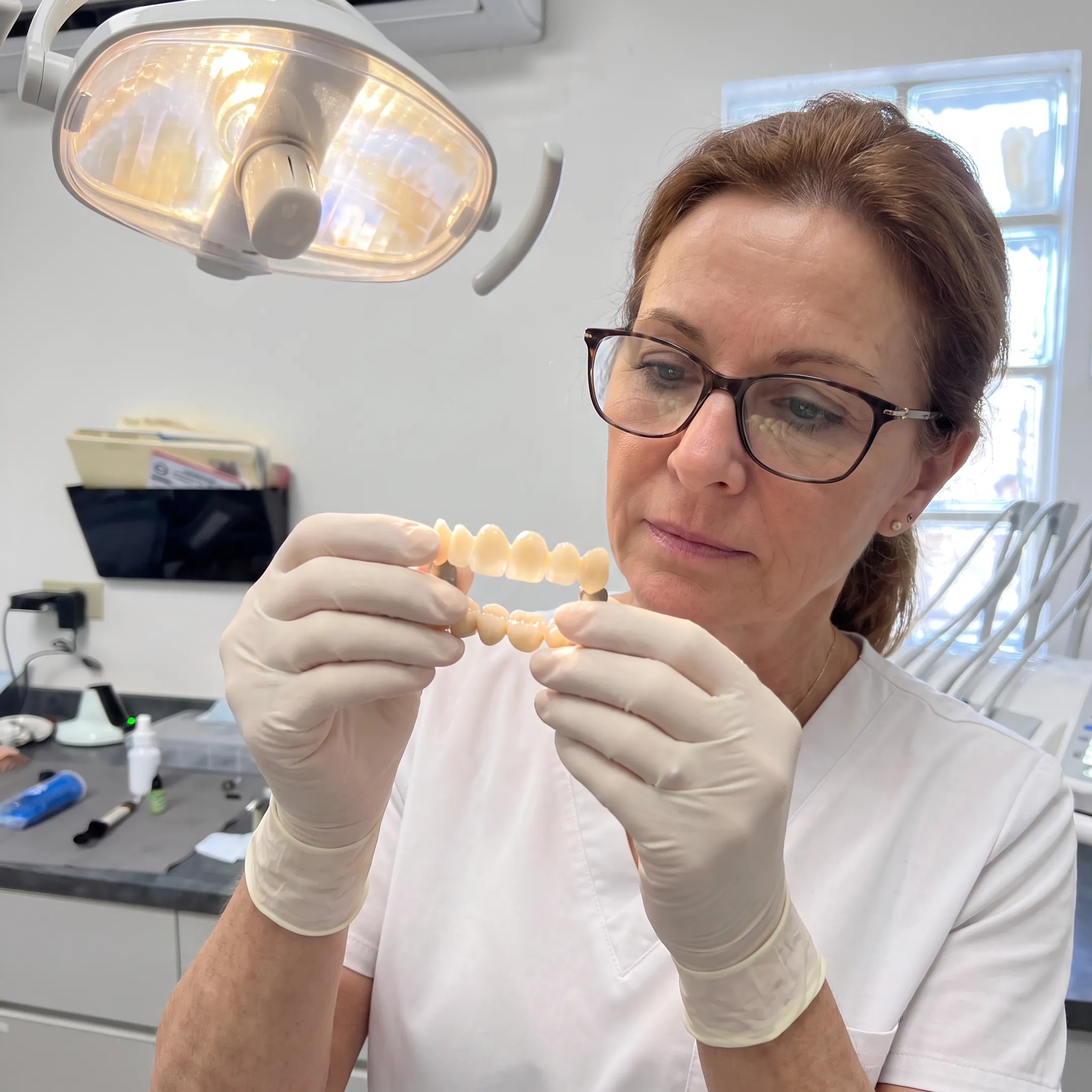 Zirconia dental crown and bridge restorations displayed beside a smiling patient in a modern dental clinic.