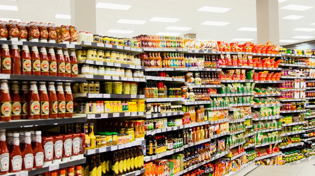 Retail grocery shelf aisle showing dense competing food product packaging