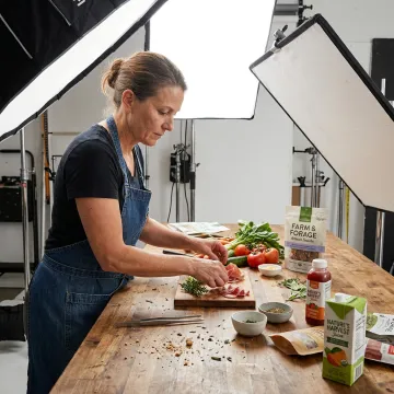 Food stylist arranging fresh ingredients for CPG product photography