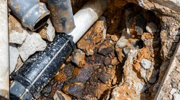 Pipeline excavation revealing gasket joint in hydrocarbon-contaminated soil environment