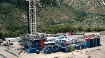 Horizontal directional oil well drilling rig operating in oilfield with derrick visible