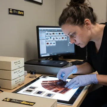 Technician organizing 35mm film for digitization
