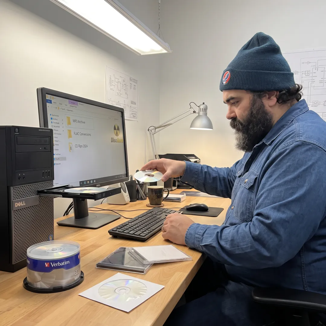 Technician organizing digital audio files from CDs