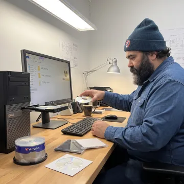 Technician organizing digital audio files from CDs