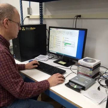 Technician organizing digital photos from discs