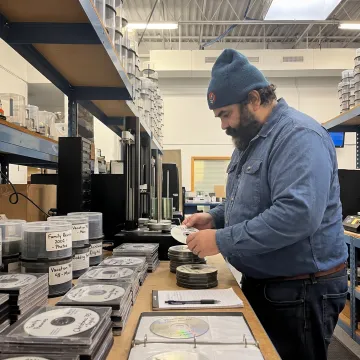 Technician organizing photo CDs for digital conversion