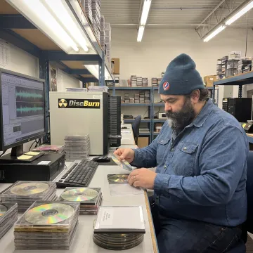 Technician organizing CDs for digital conversion