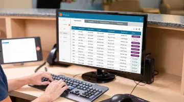 Healthcare front desk staff managing patient appointment scheduling on computer system