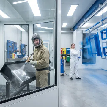 Step-by-step abrasive blasting and powder coating process on industrial metal parts