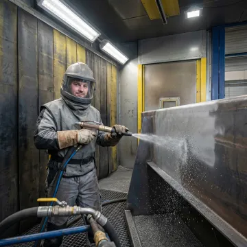 Industrial abrasive blasting and metal finishing process on fabricated steel components