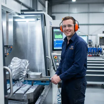 CNC machinist operating precision milling machine for aerospace component manufacturing