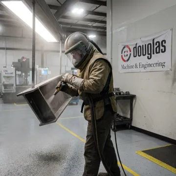 Technician preparing metal parts for powder coating