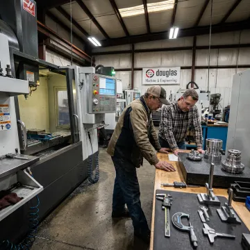 Machinist reviewing CNC workflow and inspected parts