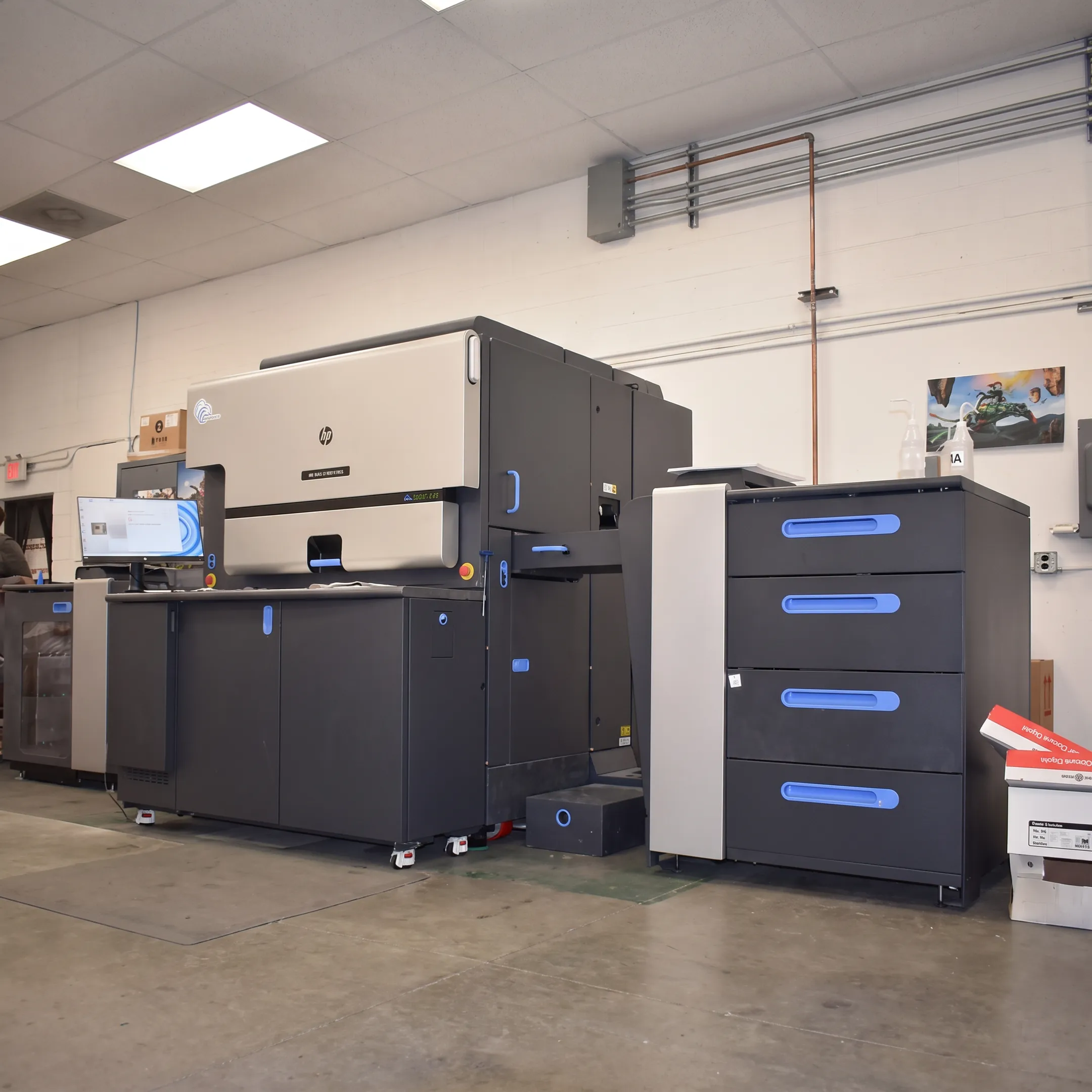 Personalized variable data postcards arranged beside digital printing and mailing equipment