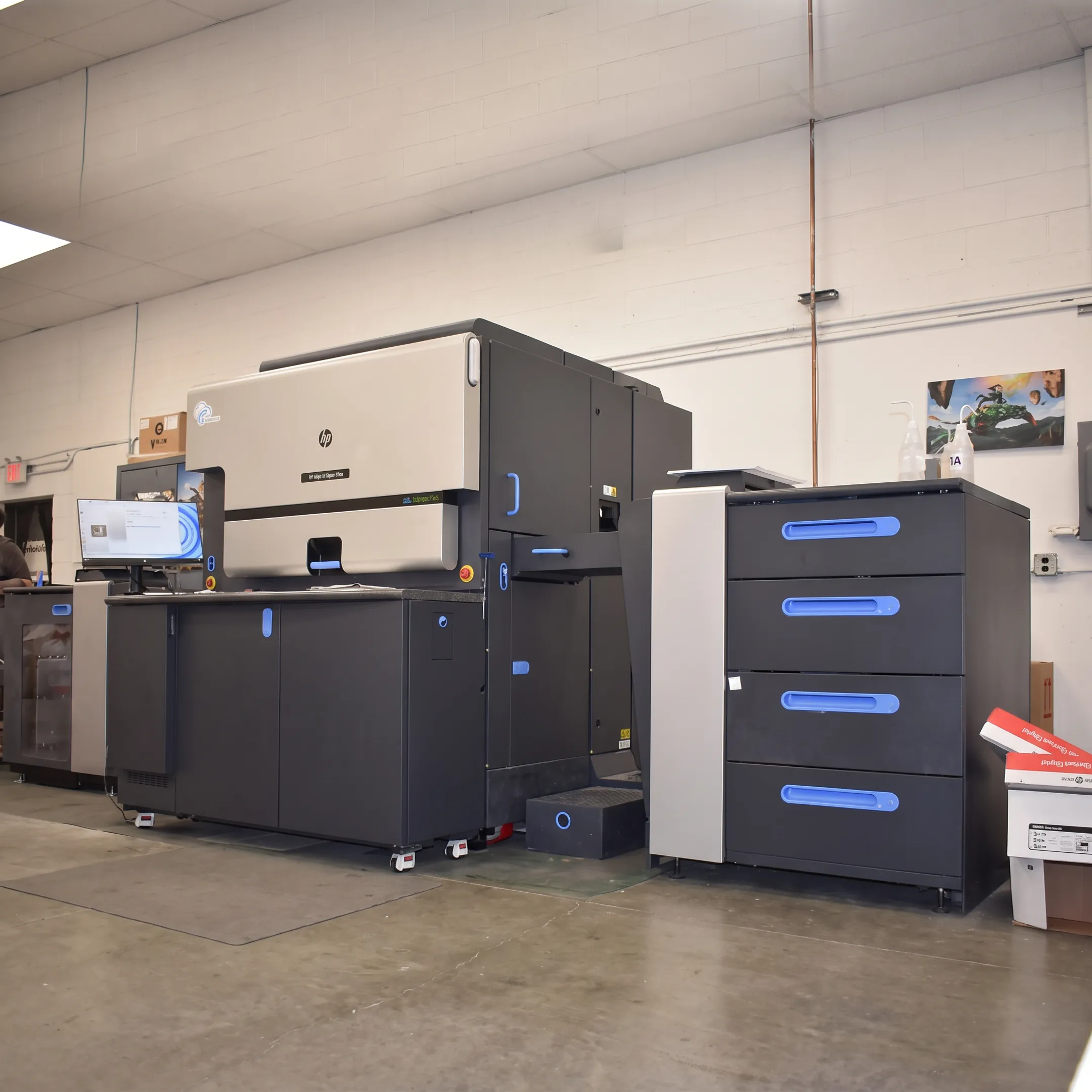 Printed marketing materials arranged beside digital printing equipment