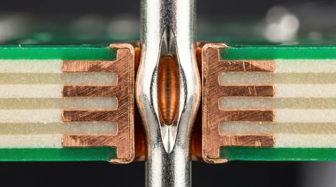 Compliant press-fit connector pins inserted into printed circuit board plated through-holes