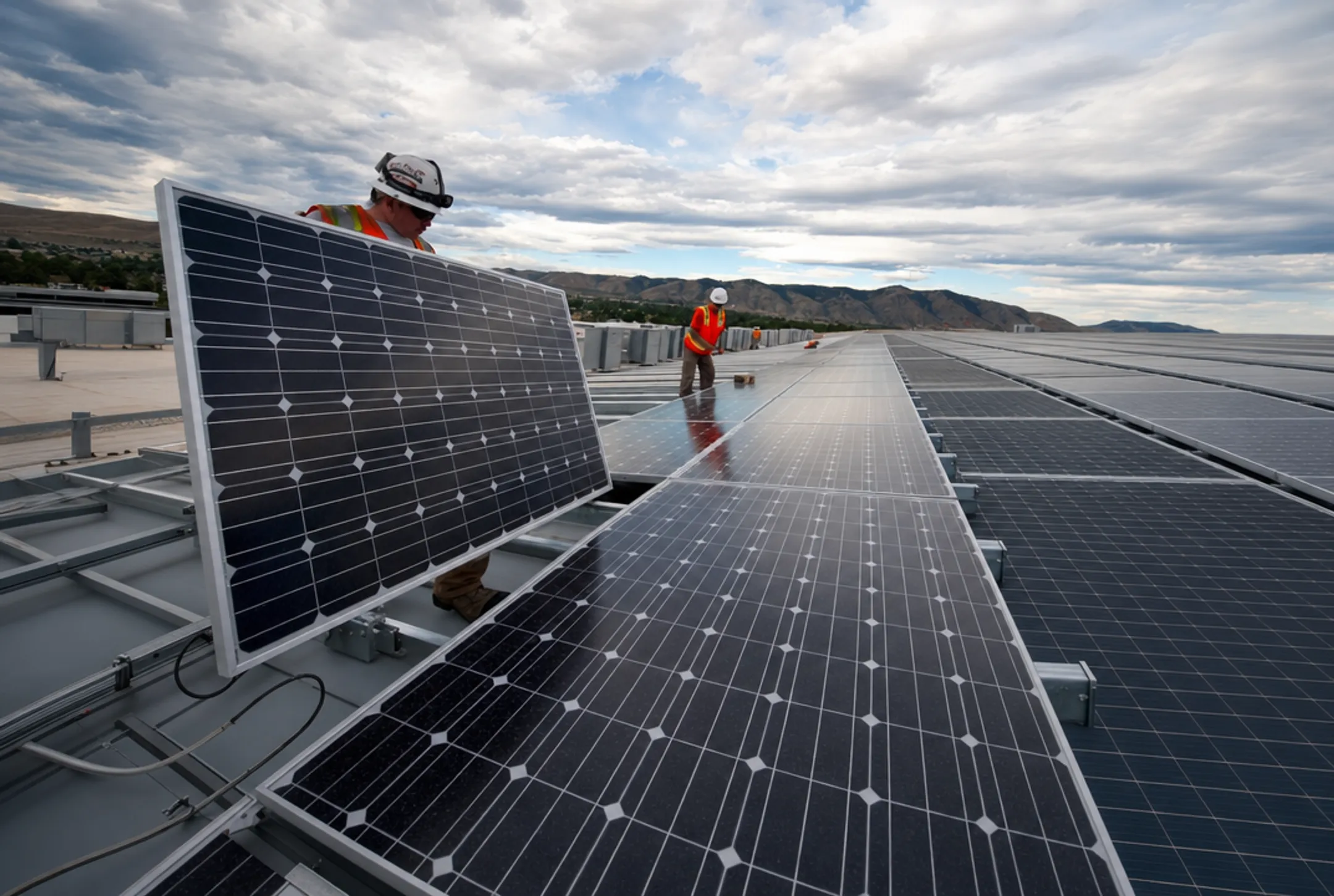 Commercial solar panel installation on business rooftop with technicians