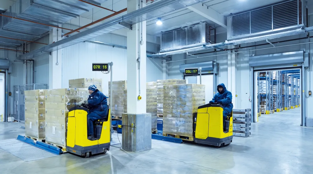 Large commercial warehouse walk-in cold storage with forklift operating inside