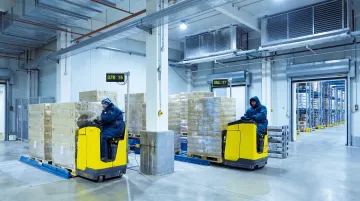 Large commercial warehouse walk-in cold storage with forklift operating inside